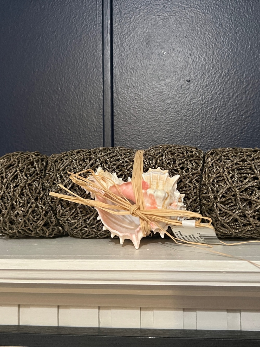 Decorative woven net with beautiful coral shell accent.